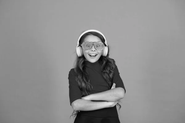 Αίσθηση κομψό και αυτοπεποίθηση. σχολικός ραδιοφωνικός dj. μικρό χαρούμενο κορίτσι ακούει μουσική στα ακουστικά. Αστείο παιδί με γυαλιά για πάρτι. Ώρα για διασκέδαση. μοντέρνο παιδί απολαμβάνει τη μουσική. Φαίνεσαι έξυπνος και αστείος. — Φωτογραφία Αρχείου