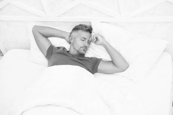 Lélegezz nyugodtan, aludj jól. Jóképű férfi az ágyban. Alvó srác otthon. Nyugodt ember. Az alvászavarok megelőzésének és kezelésének előmozdítása. Az alvás világnapja. A jó és egészséges alvás előnyei — Stock Fotó