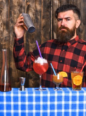 Uzun sakallı, bıyıklı ve şık saçlı bir barmen.