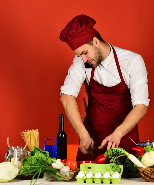 Cook fungerar i köket nära grönsaker och verktyg. — Stockfoto