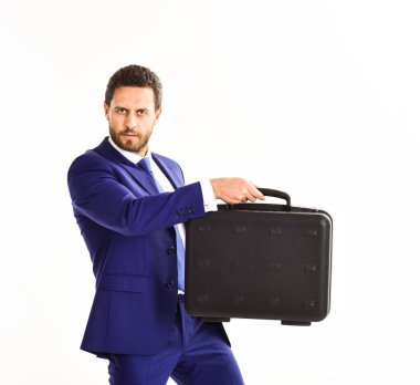 Sakallı bir iş adamı evrak çantasını sunar. Adam siyah çanta taşıyor.