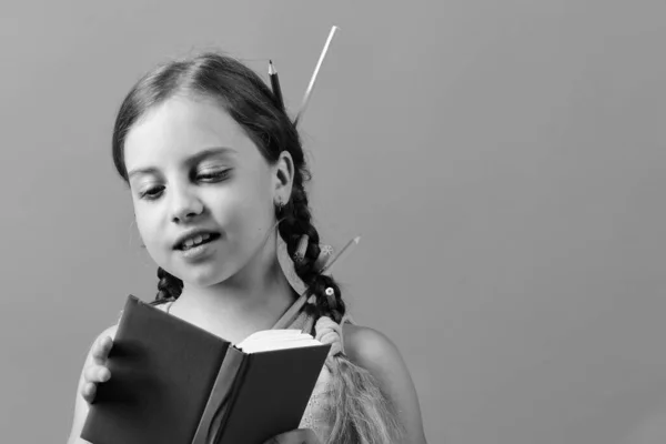 Menina lê livro azul e muda páginas. De volta à escola — Fotografia de Stock