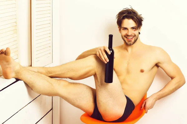 Kaukasische bärtige sexy Macho hält Flasche auf weißem Studiohintergrund — Stockfoto