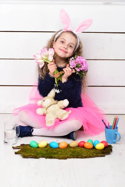 Chica feliz con juguete de conejo de Pascua, lápiz, flores de tulipán, huevos — Foto de Stock