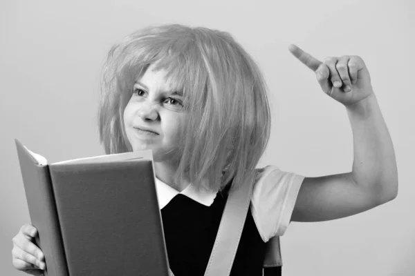 Girl holds big blue book. School girl with angry face — Stock Photo, Image