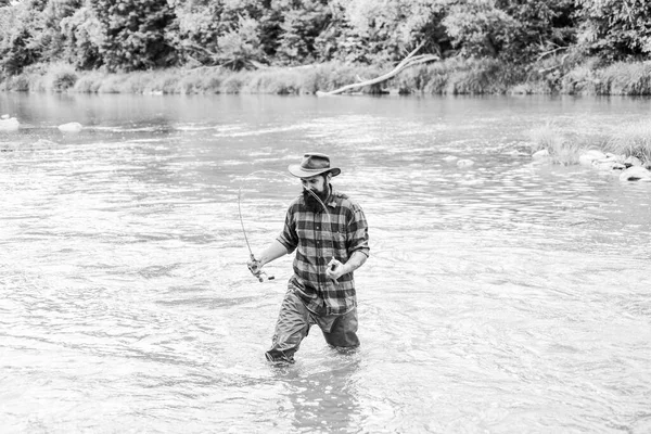 Pasatiempo masculino Fisher. Pescado en gancho. Hombre brutal parado en el agua del río. Hombre barbudo pescador. La pesca requiere ser consciente y estar plenamente presente en el momento. Equipo de pesca Fisher. Descanso y recreación — Foto de Stock