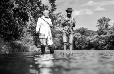 Mükemmel bir hafta sonu. Hobi ve eğlence. Aile günü. Yaz tatili. Arkadaşlar balık tutuyor. Tatil olarak balık tutmak. Resmi takım elbiseli bir balıkçı. Başarılı bir yakalayış. Zarif sakallı adam ve vahşi hippi balıkçılığı.