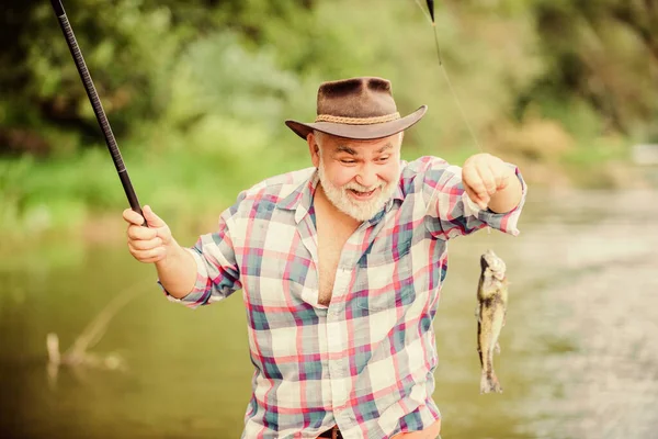 若い心で。スポーツ活動と趣味トラウト・ベイト夏の週末釣竿付きの漁師。引退したひげを生やした漁師大きな魚釣りだポツンター魚を捕る男成熟した男釣り — ストック写真