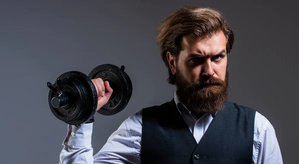 he is strong. brutal mature hipster in suit with dumbbell. business and sport. express real power. be strong in business and life. successful male with beard and moustache. businessman hold barbell