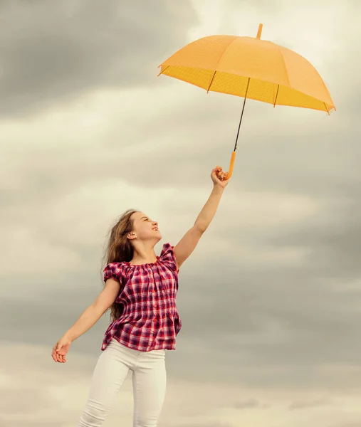 밖에 아무 걱정없는 어린이. 자유와 신선 함. 반 중력 개념. 편안 함을 즐겨요. 일기 예보. 날씨에 대비하는 거지. 날씨 변화. 신선 한 공기. 우산처럼 구름낀 하늘을 배경으로 한 소녀 — 스톡 사진