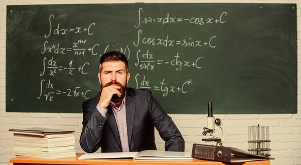 Nachdenken über ernste Probleme. ernsthafter Lehrer, der den Bart mit der Hand berührt. Bärtiger Mann mit ernstem Gesicht sitzt am Lehrertisch. Hipster mit ernstem Blick in der Schule. Problemlösung. Dilemma — Stockfoto