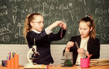 Gözbebekleri tatlı kızlar sıvı içeren test tüpleri kullanırlar. Kimyasal deney konsepti. Güvenli kimyasal reaksiyon sağlamak için güvenlik önlemleri. Dahi çocuklar kendi kimyasal teorileri üzerinde çalışırlar. Kimyanın temel bilgisi