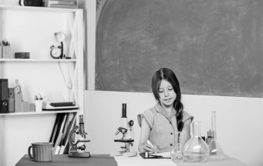 Biyoloji eğitimi. Fen dersi. Okul laboratuarı. Mikroskobu olan küçük bir kız. Kız biyoloji sınıfı test tüpleri. Bilimsel deney. Büyüleyici bir ders. Mikrobiyolojiyi araştır. Biyoloji oku.