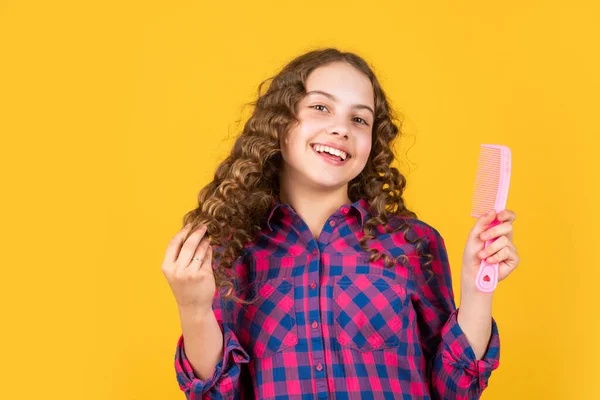 Een kind dat krullen poetst. Sterk en gezond haar concept. Klein kind lang haar. mode-accessoire gereedschap. Gelukkig meisje met haarborstel. gezond en sterk haar. kapsalon schoonheidssalon. Feesttijd — Stockfoto