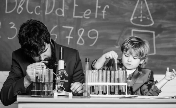 Touching Lives Forever. father and son at school. teacher man with little boy. school lab equipment. Back to school. using microscope in lab. student doing science experiments with microscope in lab