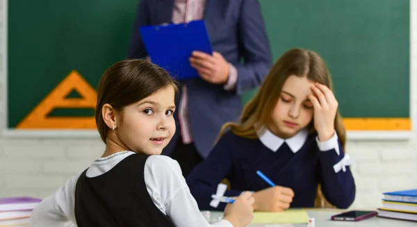 Estudiantes enfocados y concentrados. Proceso de control. Probando estudiantes. Pedagogo. Mirándolos. Aula de profesores y niños. La vida escolar diaria. De vuelta a la escuela. Ayuda y apoyo. Niños y maestro — Foto de Stock