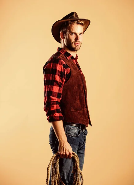 América Ocidental. cowboy com corda de laço. Ocidental. Homem de estilo vintage. cowboy retro do Oeste Selvagem. Camisa xadrez no rancho. Retrato de cowboy ocidental. rodeio oeste selvagem. homem de chapéu — Fotografia de Stock