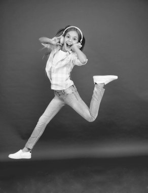 Havada zıplıyor. Mutlu küçük kız dansları. Sevimli çocuk mutlu dans müziğinden hoşlanıyor. Müzik onun için mutluluk. Kolay müzik. Kulaklıkla müzik dinleyen küçük bir kız. Dans eden kız.