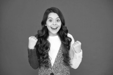 Bir kazananımız var. Mutlu kazanan kırmızı arka plan. Küçük kız kazanan hareketi yapar. Zaferi ya da başarıyı kutlayın. Çocuk şampiyonu. Moda ve güzellik. Gerçek kazananın neye benzediğini. Çocukluk mutluluğu