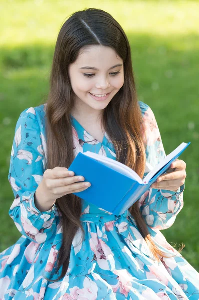 Dla przyjemności czytania. Szczęśliwa dziewczyna czyta książki w letnim parku. Małe dziecko lubi czytać na świeżym powietrzu. Letnia lista lektur. Rozwijanie wyobraźni. Czytanie jest zabawne. — Zdjęcie stockowe