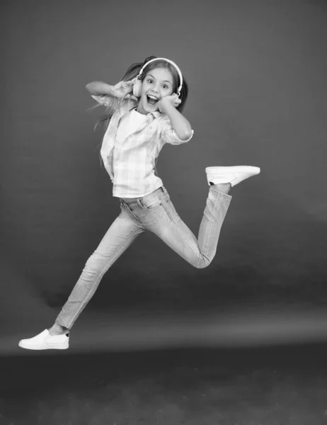 Salto a mezz'aria. Felice bambina che balla. Bambino carino godendo di musica da ballo felice. La musica è felicità per lei. Musica facile da ascoltare. Ragazzina che ascolta musica in cuffia. Ragazza ballerina — Foto Stock