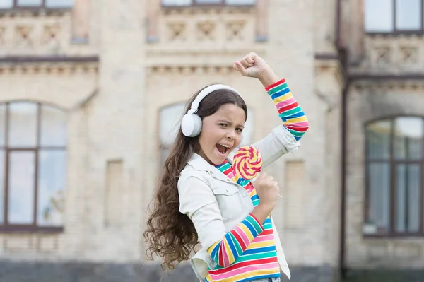 Back to vocal school. happy beauty outdoor. kid innovating education. happy childrens day. healthy lifestyle. schoolgirl with lollipop. happy kid in headset. pupil listen music and sing song — Stock Photo, Image