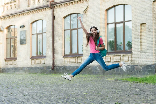 Jag delar glädje. Glada barn tillbaka till skolan. Lycklig barndom. Energisk tjej hoppar till musik. Sommarsemester. Trevlig helg. Spela lyckliga stunder. Internationella barnens dag — Stockfoto