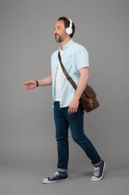 Favori şarkılarla yürüyorum. Kablosuz kulaklıklar. Müzikle her şey daha iyi. Mutlu adam müzik dinler. Olgun insan müzikten hoşlanır. Müzik kulaklığı sesi. Modern teknoloji. Şehir hayatı