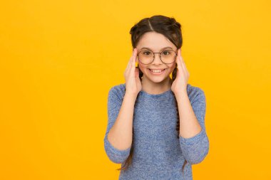 Göz aksesuarı kesinlikle işe yarar. Mutlu kız sarı arka plan gözlük takıyor. Moda aksesuarı. Tasarımcı gözlüğü. Bardaklar indirimde. Optik çerçeveler al. Moda aksesuar aslında aksesuar değildir, kopyalama alanı