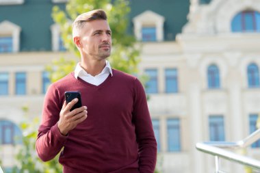 Mesaj gönder. Taşınabilir yaşam tarzı. İnternet bağlantısı. Kullanışlı bir uygulama. İş iletişimi. Çevrimiçi iletişim. Modern iletişim. İş adamı cep telefonunu tutar. Telefonu olan yakışıklı bir adam.