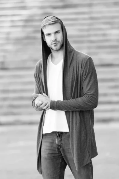 handsome man with hood standing in urban city interior. informal style clothing. Fashionable young model man. Mystery man posing with hoodie. young street man with hood. Incognito Boy