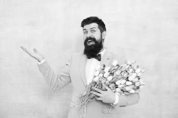 Shop now. Happy hipster with tulips. Bearded man with spring flowers. Flowering present. Floral present for Valentines day. Valentines or womens day present. Valentine man hold empty hand, copy space — Stock Photo, Image