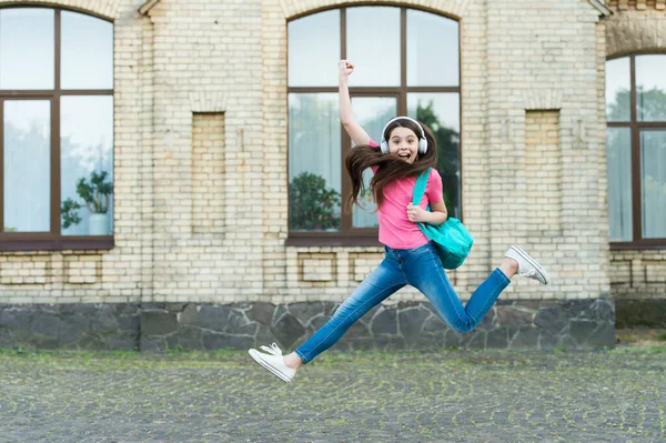 Die Ferien kommen. Glückliche Kinder feiern Ferien im Freien. Aktive Mädchen springen zur Musik. Schulferien. Sommerferien oder Urlaub — Stockfoto