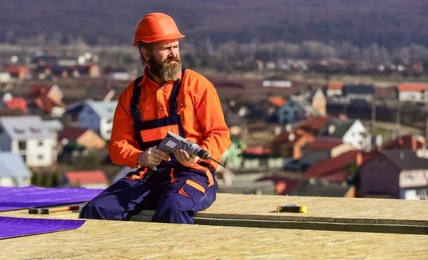 Çatı tamircisi. Çatıda adam var. Malzeme gereksinimleri. Çatının yalıtım yüzeyine kısmen üst üste binen malzeme katmanları yükle. Ana onarım çatısı. Düz çatı kurulumu