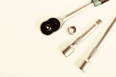 Başların başlıca avantajı gevşemek ya da vida ve cıvataları sıkmak için bir yerlere ulaşmak zordur. Ev geliştirme araçları konsepti. El aletlerinde mandal ve soketler için alışveriş yap. Tamir ve inşaat araçları