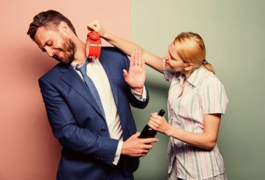 Kavga eden çift. Karım kocasının neden bu kadar geç geldiğini merak ediyor. Aile rutini. İlişki sorunları. Aile psikolojisi. mutsuz bir hayat. Alkolik adam şarap içer. Kadın alarmlı saati göster