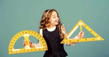 Matematik öğren. Teoriler ve aksiyomlar. Zekice ve zekice bir fikir. Büyük cetveli olan kız. Öğrenci geometri okuyor. Çocuk okulu üniforması cetveli tutar. Okul eğitimi konsepti. Boyut ve ölçü