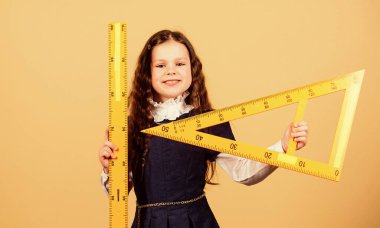 Eğitim ve okul konsepti. Zekice ve zekice bir fikir. Boyut ve boyut. Büyük cetveli olan tatlı bir öğrenci. Öğrenci geometri okuyor. Çocuk okulu üniforması cetveli tutar. Matematiği severim.