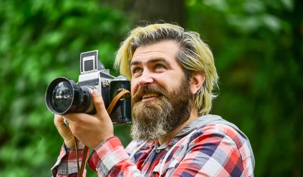 Férias de Verão. fotógrafo segurar câmera retro. jornalista é a minha carreira. repórter fazer foto. Câmera vintage. capturar essas memórias. Câmara SLR. hipster homem com barba usar câmera profissional — Fotografia de Stock