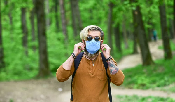 Walk in blue medical mask in forest. Preventive methods from coronavirus. coronavirus quarantine. take care of your health. healthcare. man wear protective respirator mask outdoor — Stock Photo, Image