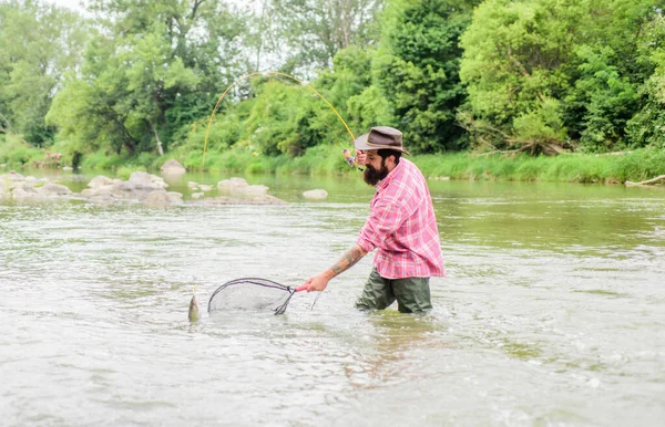Flash Sport Fishing. hobby and sport activity. pothunter. summer weekend. Big game fishing. bearded fisher in water. mature man fly fishing. man catching fish. fisherman with fishing rod