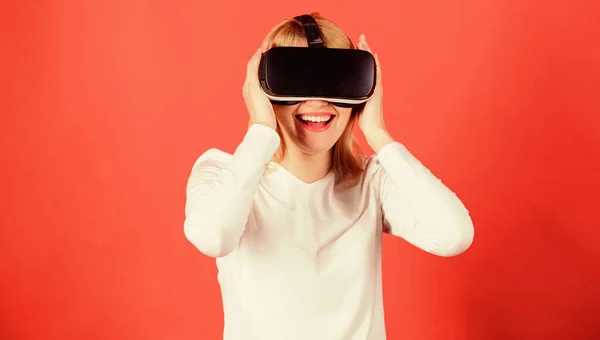 Egy fehér blúzos nő portréja virtuális valóság szemüveggel a fején, vörös háttérrel elszigetelve. Happy woman exploring augmented world, interakció a digitális felület. — Stock Fotó