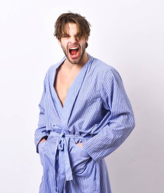 Manyak suratlı adam şık bir evde ya da banyo kıyafetlerinde.