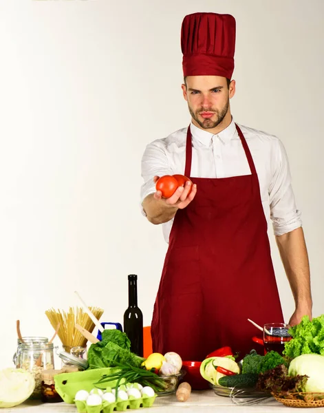 Koch oder Köchin hält Tomate am Küchentisch mit Gemüse — Stockfoto