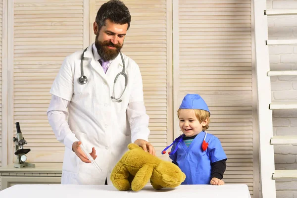 Vader en kind met blije gezichten doktertje spelen. — Stockfoto