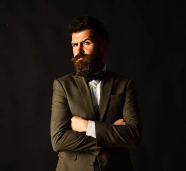 Eskimiş şık takım elbiseli ve kahverengi arka planda yelek giyen adam..