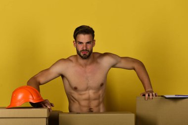 Ciddi yüzlü maçonun miğferi ve klasörü var..