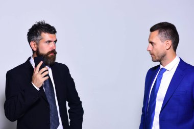 Gri arka planda resmi takım elbiseli katı yüzlü iş adamları..