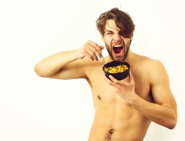 Kafkas seksi genç maço elinde makarna ile siyah kase tutuyor.