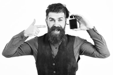 Sakallı adam, elinde mutlu yüzle parfüm tutuyor.